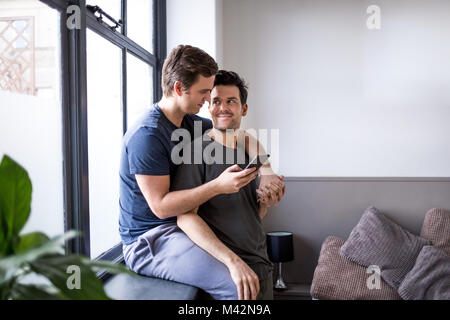Young male couple making plans with smartphone Stock Photo