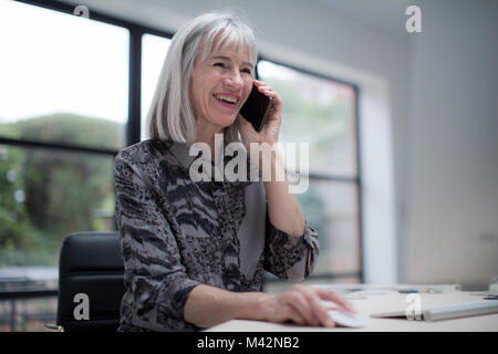 Senior businesswoman multitasking technology Stock Photo