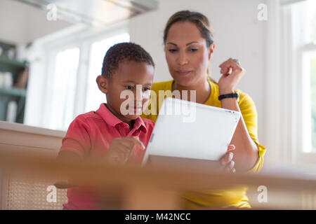 Mother teaching Son how to use digital tablet Stock Photo