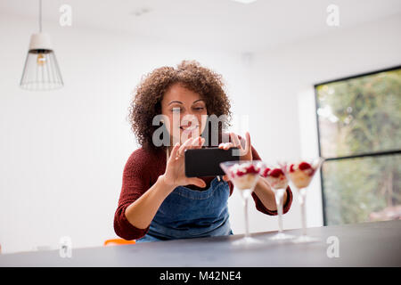 Female food blogger taking a photo with smartphone Stock Photo