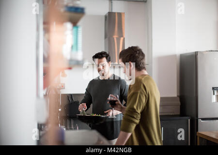 Young male couple cooking in kitchen Stock Photo