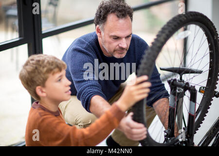 Father teaching Son how to care for his bicycle Stock Photo