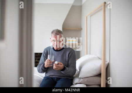 Senior man taking medicine Stock Photo