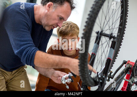 Father showing Son how to care for his bicycle Stock Photo