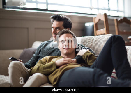 Portrait of young male couple relaxing on sofa Stock Photo