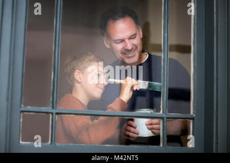 Son helping Father how to decorate Stock Photo