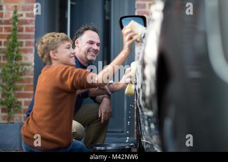 Son helping Father wash car Stock Photo