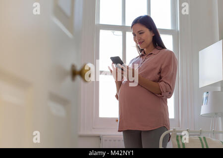 Pregnant woman using smartphone Stock Photo