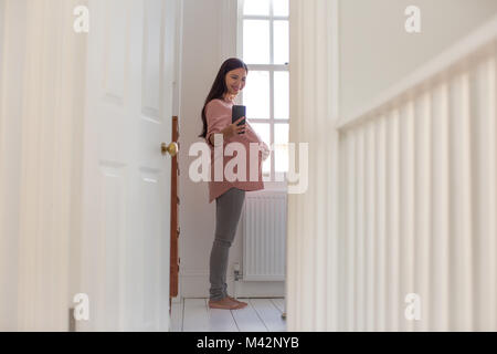 Pregnant woman taking selfie with smartphone Stock Photo