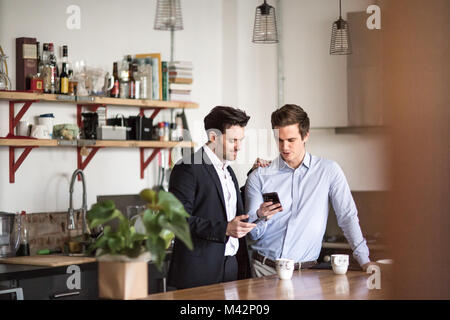 Young male couple in kitchen having breakfast before work Stock Photo