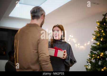 Man giving woman Christmas gift Stock Photo