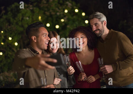 Friends celebrating outdoors taking a selfie Stock Photo