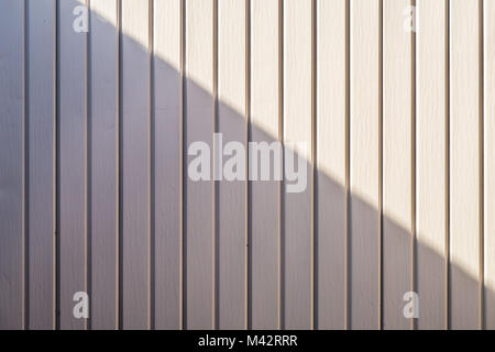 Pink metal painted wall with diagonal shadow from top left to bottom right Stock Photo