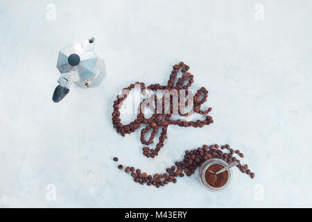 Word Coffee made with coffee beans. High key drink photography with Moka pot and food lettering. Creative top view hot drink concept with copy space. Stock Photo