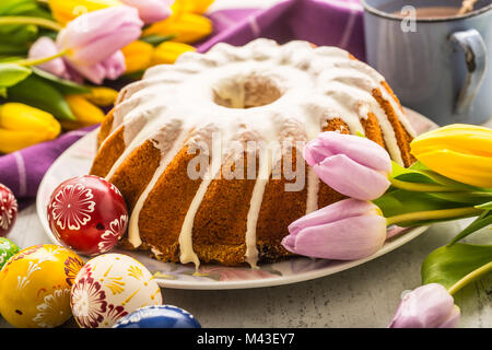 Easter Cake. Traditional ring marble cake withe easter decotation. Easter eggs and spring tulips. Stock Photo