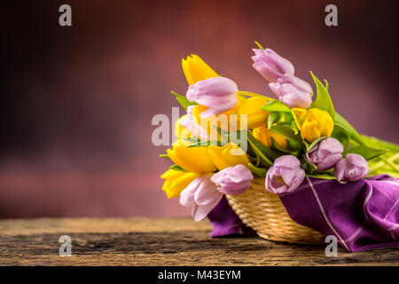Tulips. Bouquet of Spring tulips yellow and pink on wooden table. Stock Photo