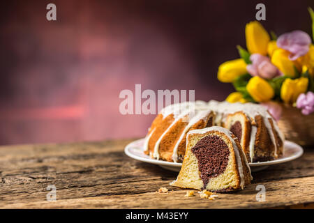 Easter Cake. Traditional ring marble cake withe easter decotation. Easter eggs and spring tulips. Stock Photo