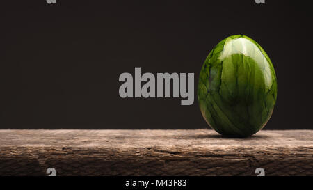 Green Easter egg on a rustic wooden table, Happy Easter background Stock Photo