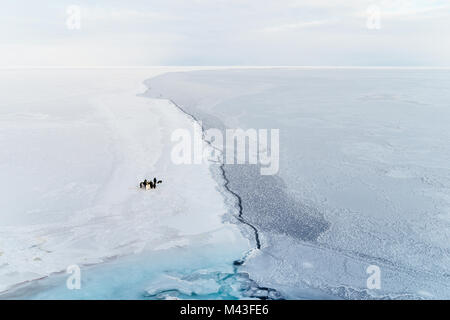 A small group of emperor penguins near a crack in the sea ice. Ross Sea, Antarctica. Stock Photo