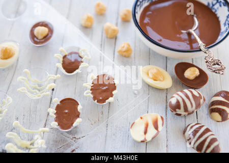 Homemade milk and white chocolate Easter eggs on a rustic table. Stock Photo