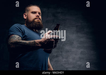Bearded man holds the beer bottle. Stock Photo