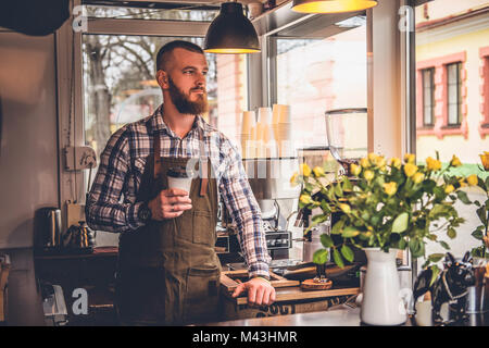 Redheads craft coffee seller in a small street cafe. Stock Photo