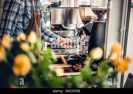 A man preparing cappuccino in a coffee machine. Stock Photo