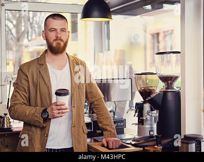 Redheads craft coffee seller in a small street cafe. Stock Photo