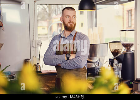 Redheads seller in a small coffee house. Stock Photo