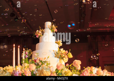 Candlestick and wedding cake on the glass table at the stage in wedding ceremony. Wedding Ceremony tools and decorations concept. Stock Photo