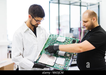 Portrait of young engineer holding CMTS card Stock Photo