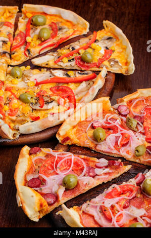 Pizza with tomato, salami, peppeeoni, olives and yellow hot pepper Stock Photo