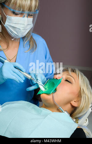 dentist with patient, using dental curing light Stock Photo