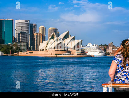 Group of tourists enjoying a beautiful view of Sydney, Australia, skyline from the boat on a clear day; famous Sydney Opera House in the center Stock Photo