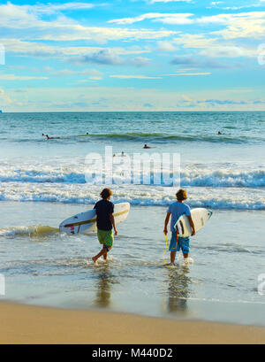 CANGGU, BALI ISLAND, INDONESIA - JAN 19, 2017: Two of surfers going to surf on the beach. Bali island is one of the worlds best surfing destinations Stock Photo