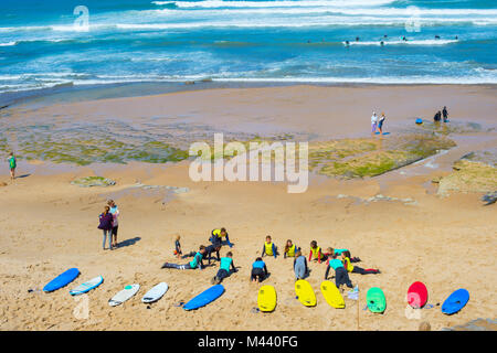 ERICEIRA, PORTUGAL - JUL 23, 2017: Coach show how to surf to the group of surfers. Ericeira is the famous surfing destination in Portugal. Stock Photo