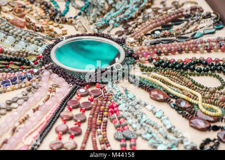 Gemstone bracelets and necklaces made of malachite, rose quartz, larimar, mahogany obsidian, unakite, amethyst, chalcedony, green jasper stones and cr Stock Photo