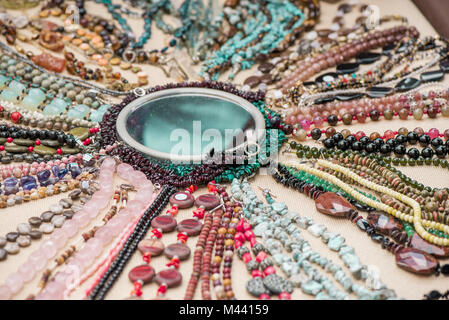 Gemstone bracelets and necklaces made of malachite, rose quartz, larimar, mahogany obsidian, unakite, amethyst, chalcedony, green jasper stones and cr Stock Photo