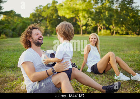 Family playing with a ball in the park.  Stock Photo