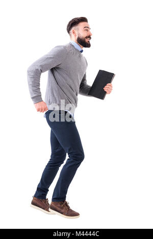 Funny excited young smart casual business man running with notebook in hands. Full body length portrait isolated on white studio background. Stock Photo