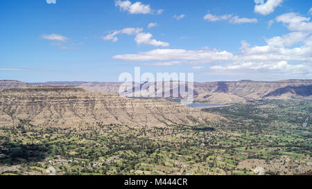 Mountain ranges of Panchgani under blue skies and the valleys with small towns and dry lands in the rain shadow area of the western ghats Stock Photo