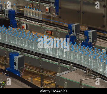 Plastic water bottles on conveyor and water bottling machine industry Stock Photo