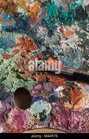 Paintbrushes, artist palette, oil paints on desk in painter studio. Close  up Stock Photo - Alamy