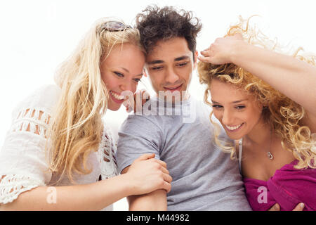 Friends huddled together smiling, looking down Stock Photo