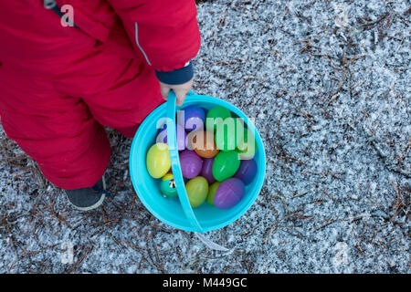 Boy with bucket of toy eggs Stock Photo