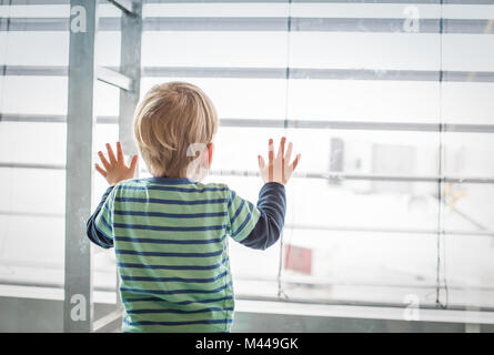 Boy looking out of window Stock Photo