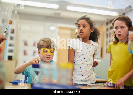 Primary schoolgirls and boys doing experiments in classroom Stock Photo