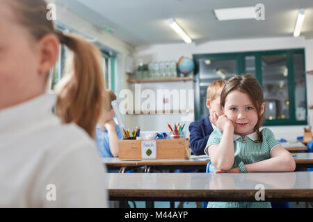 Portrait of schoolgirl sitting at primary school classroom desk Stock Photo