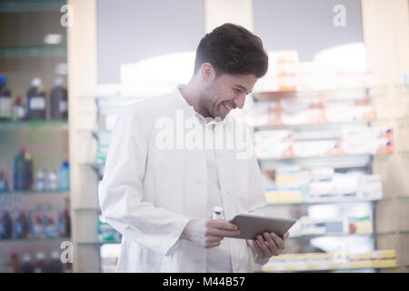 Young male pharmacist using digital tablet in pharmacy Stock Photo