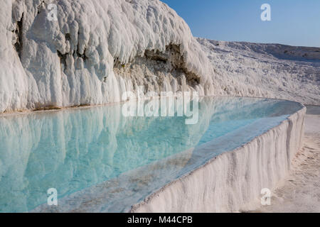 The enchanting pools of Pamukkale in Turkey. Pamukkale contains hot springs and travertines, terraces of carbonate minerals left by the flowing water. The site is a UNESCO World Heritage Site. Stock Photo